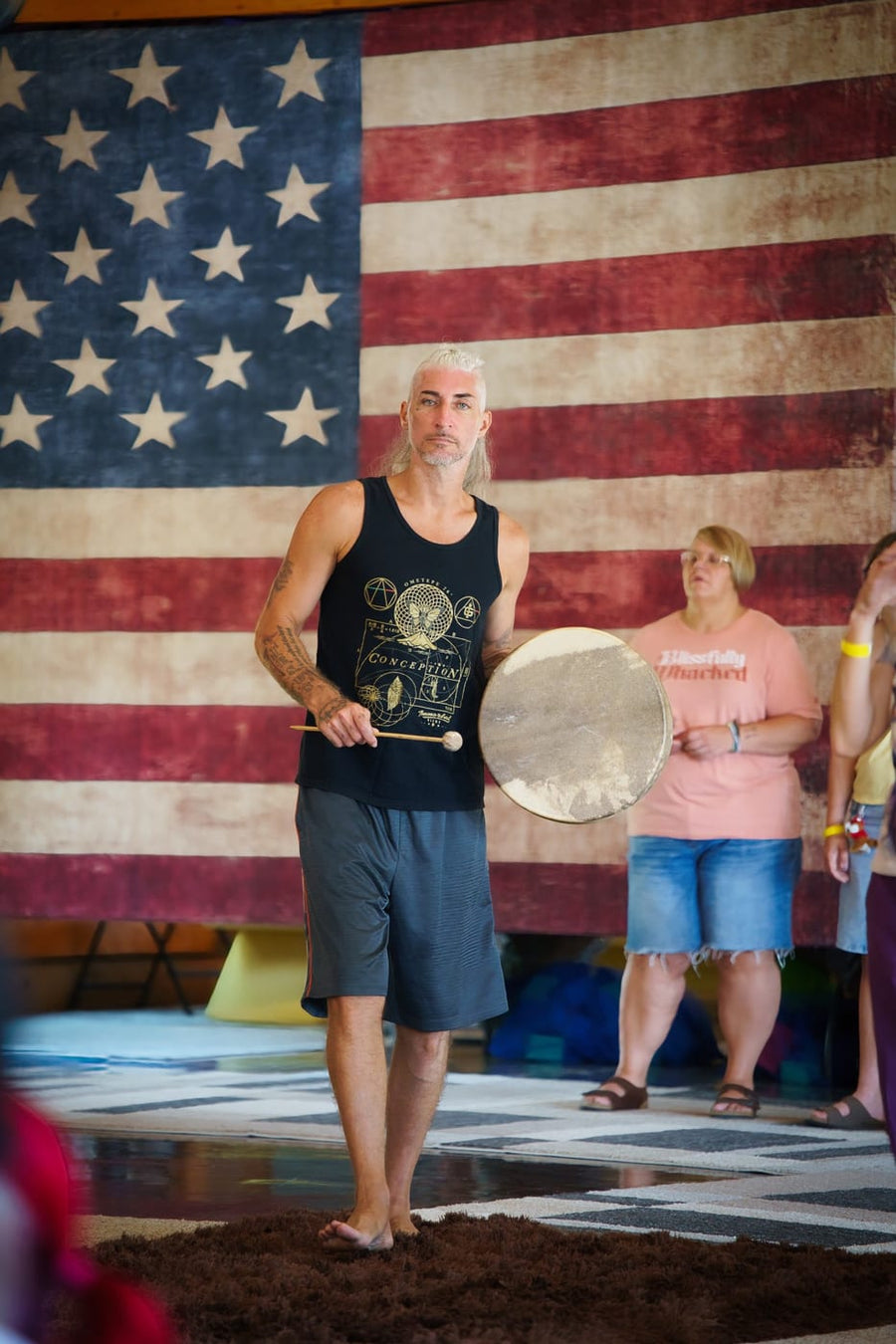 Frame drum in hand before the flag