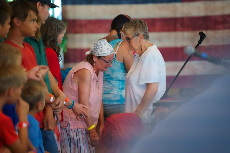 Hands laid in prayer while the young ones look on