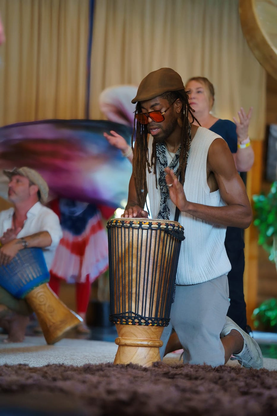 Djembe mid-rhythm as a dancer passes